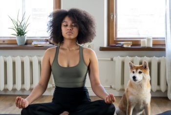 woman does a virtual yoga workout at home with her dog for back to school fit tips